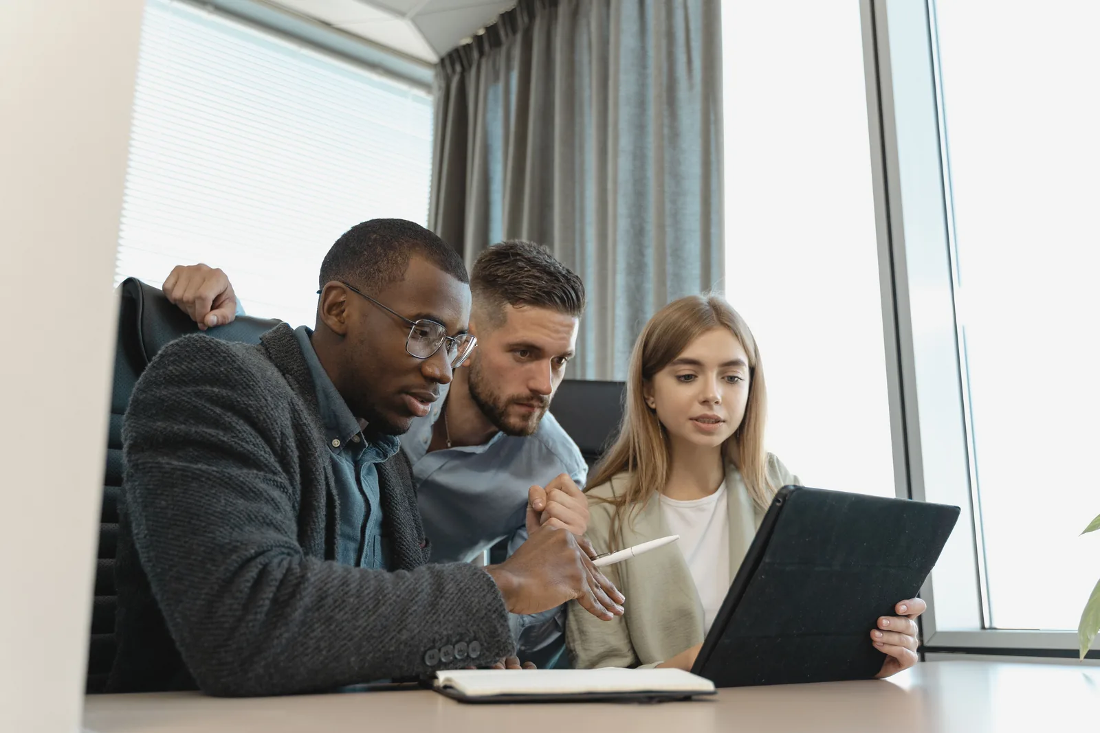 Business professionals collaborating around a digital tablet